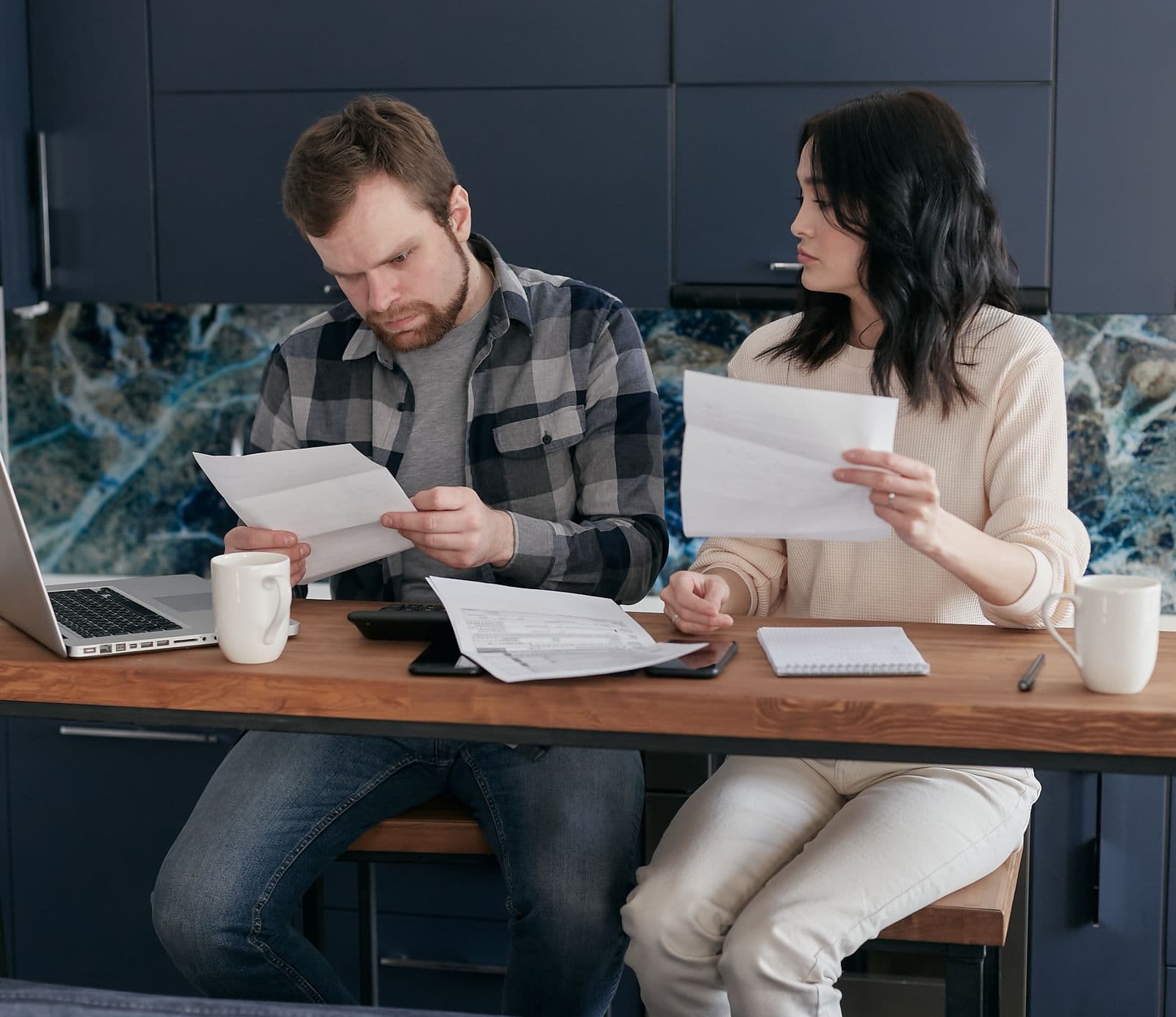 A couple reviewing financial documents with concern