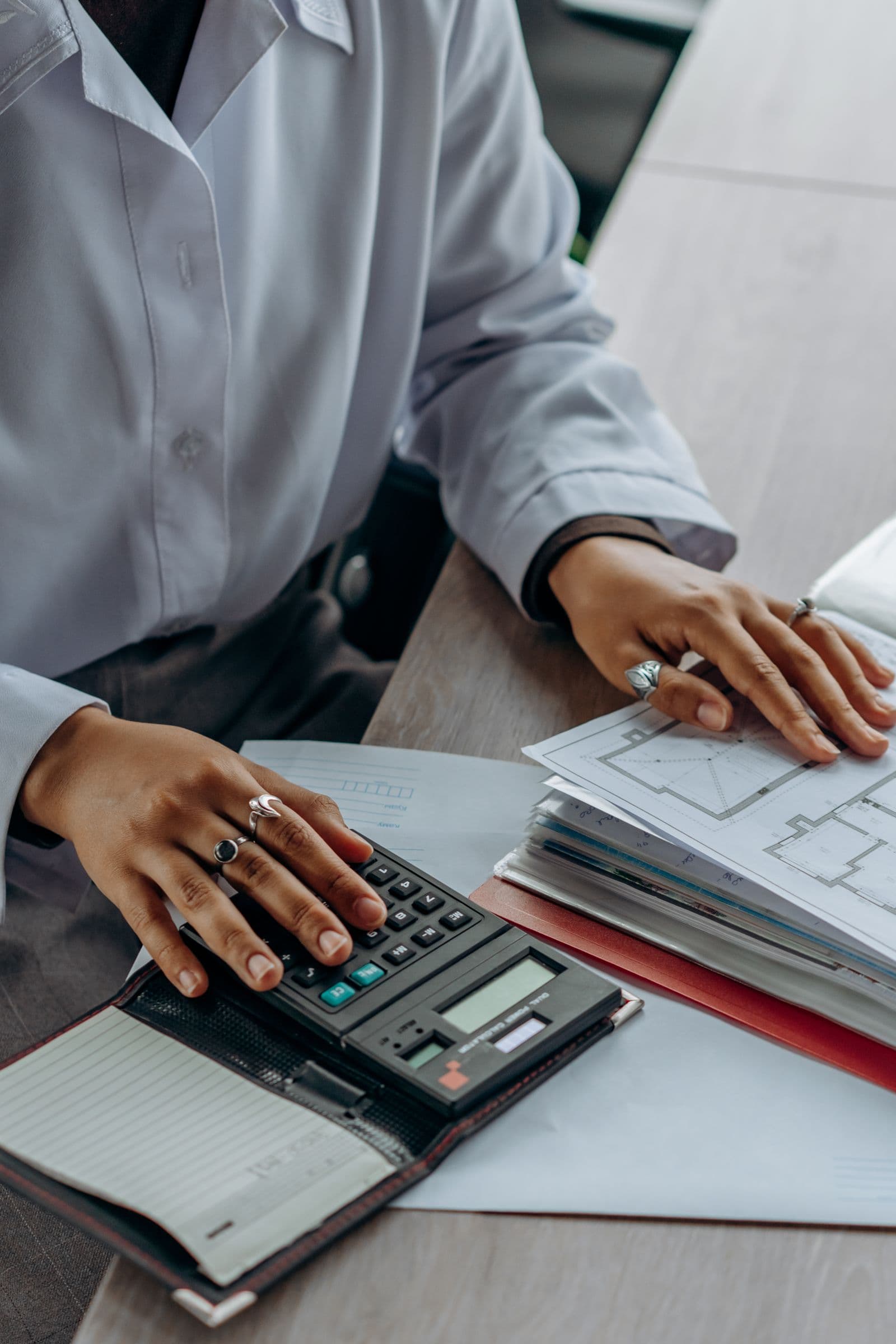 A person calculating costs from financial documents